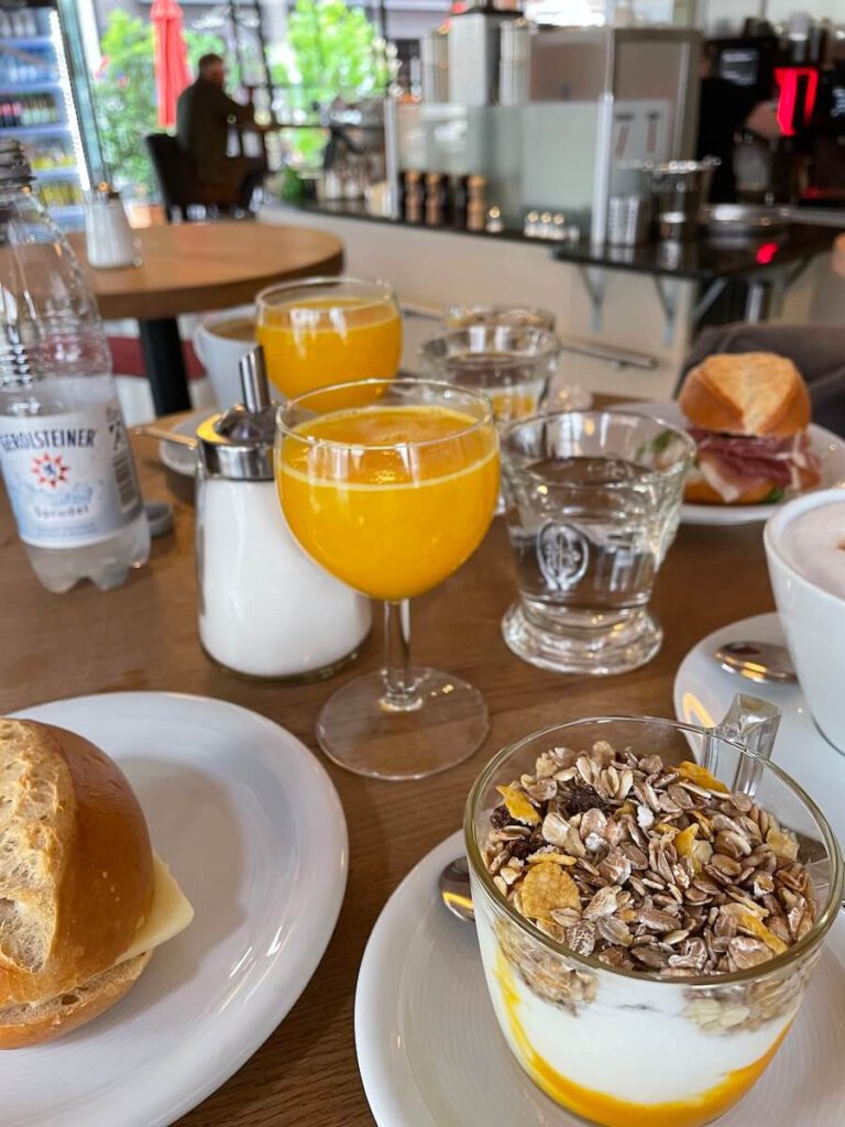 Frühstückstisch mit Orangensaft, Müsli, Käse- und Schinkenbrötchen im Engels Café auf der Hohestraße in der Düsseldorfer Carlsdtadt.