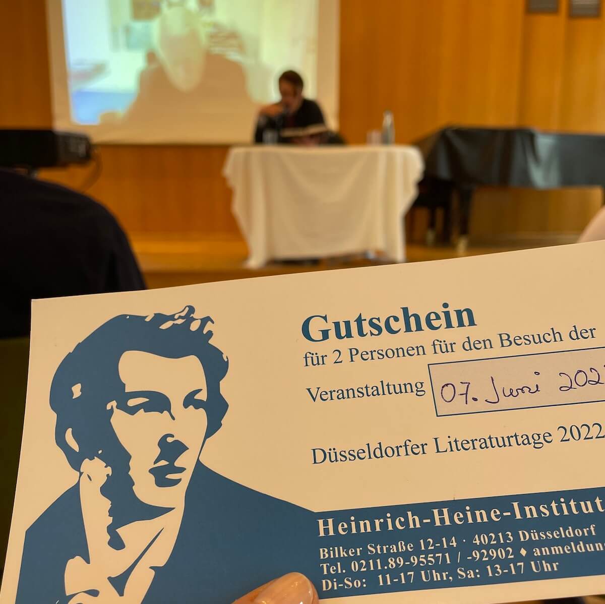 Alexander Kluge zu Gast im Palais Wittgenstein, Düsseldorf; Im Vordergrund ist ein Gutschein über zwei Eintrittskarten zu sehen.